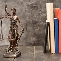 Close-up view of antique statue of lady justice and books, Law concept